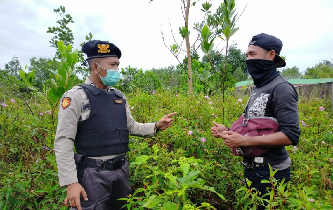 Personel Polsek Danau Sembuluh Bripka Gatot Wahyudi terlihat menyambangi warga yang sedang berada di ladang guna memberikan sosialisasi, Rabu (3/2/2021). Foto : Tbn