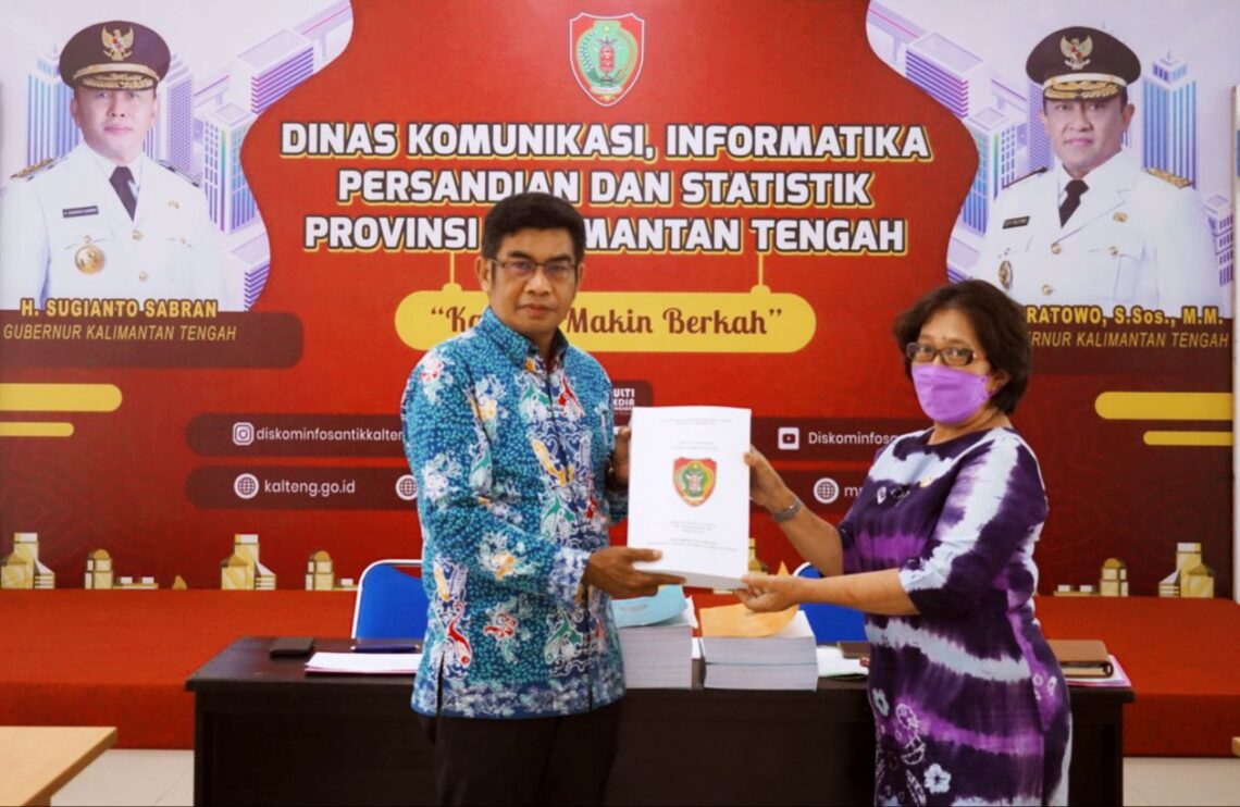 Kepala Diskominfosantik Prov Kalteng Agus Siswadi saat menerima secara simbolis DUPAK JFT Pranata Humas Periode I Tahun 2022 dari Kepala Sekretariat Tim Penilai JFT Pranata Humas Tuty Sulistiyowati