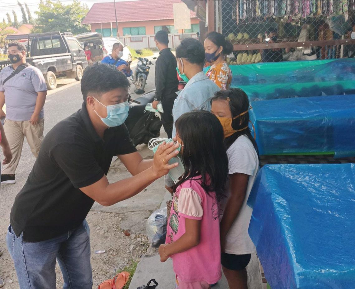 Jajaran Polres Gumas sedang memakaikan masker kepada anak-anak. FOTO : tbn.