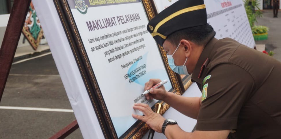 Kepala Kejaksaan Tinggi (Kajati) Kalteng Iman Wijaya, S.H., M.Hum., sedang menandatangani Maklumat Pelayanan. FOTO : penkum kejati kalteng.