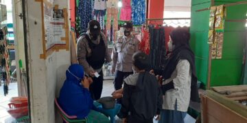 Personil Sat Binmas Sambil Membagikan Masker di Pasar Saik