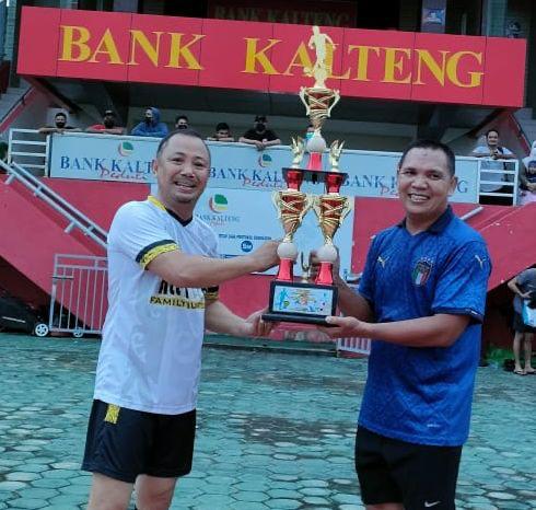 Ketua KONI Kalteng, H Eddy Raya Samsuri, saat menyerahkan Trophy kepada Juara Tropeo, yang diterima Gajali Rahman dari tim All Star Palangka Raya, Minggu (12/12/2021). Foto : Ist