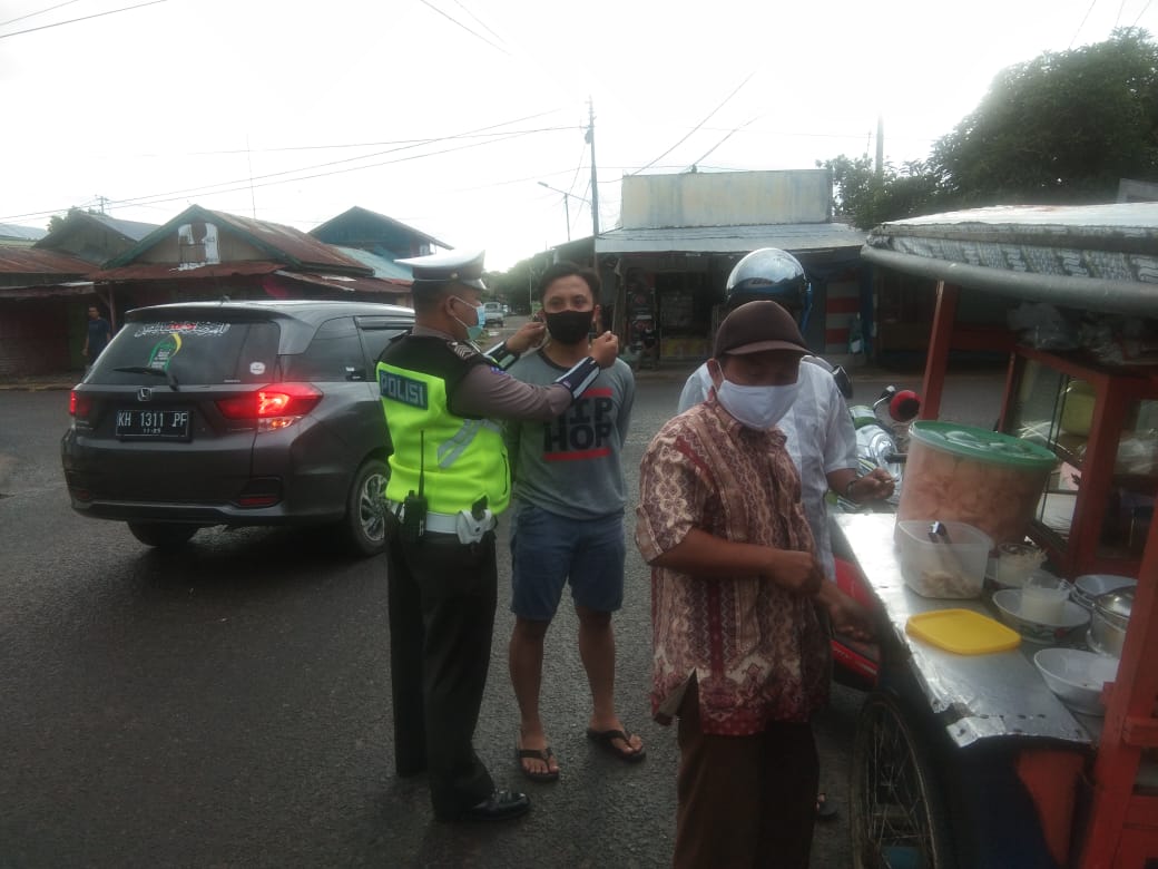 Personil Sat Lantas Polres Seruyan memasang masker kepada warga tak memakai masker, Rabu (13/1/2021). Foto : TN