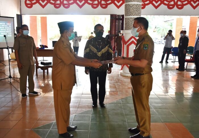 Wakil Bupati Kapuas Drs. H. M. Nafiah Ibnor, MM menyerahkan secara simbolis Surat Keputusan Bupati Kapuas kepada Tim Percepatan Akses Keuangan Daerah (TPAKD) Kabupaten Kapuas Tahun 2021 yang diberikan kepada Sekretaris Daerah Kabupaten Kapuas Drs. Septedy, M.Si, Selasa (13/7/2021) pagi di Aula Kantor Bupati.