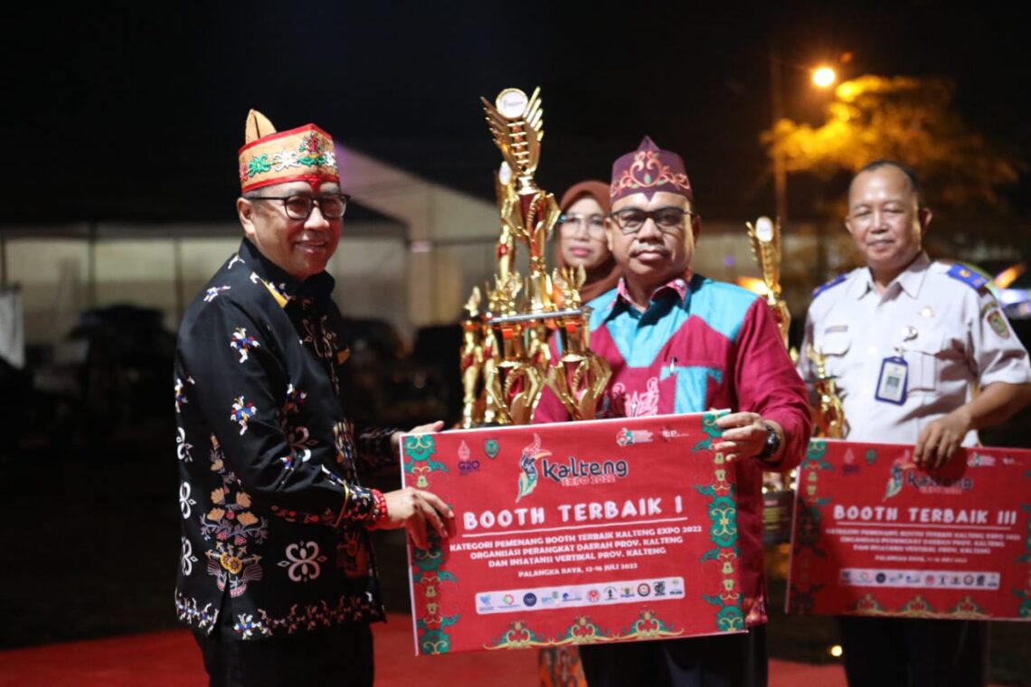Asisten Bidang Perekonomian dan Pembangunan Setda Prov. Kalteng Leonard S. Ampung saat menyerahkan pemenang booth terbaik Kalteng Expo 2022. Foto : mmc