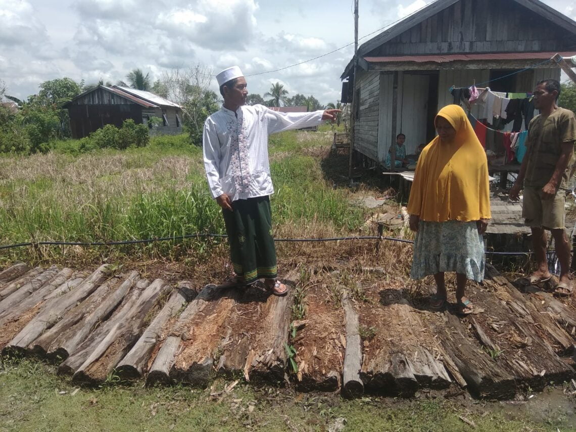 Rahmad salah satu warga jalan Padat Karya Gang Bayah RT 1 Kelurahan Barimba Kecamatan Kapuas Hilir menunjukan kondisi jalan yang memprihatinkan. Foto : Lg