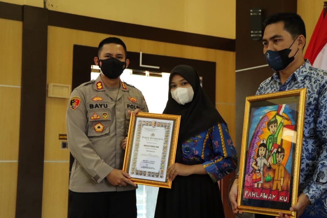 Kapolres Seruyan menyerahkan hadiah lomba melukis kepada pelajar SD, SMP dan SMA yang juara dalam rangka memperingati Hari Pahlawan Tahun 2021 di lingkungan Polres Seruyan, Rabu (17/11/2021). Foto : Tbn