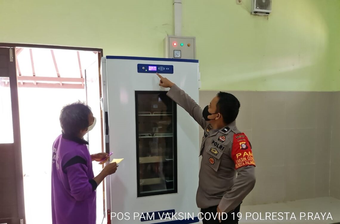 Anggota Polresta Palangka Raya sedang mengecek temperatur lemari pendingin agar tetap stabil sehingga vaksin yang disimpan tetap dalam kondisi baik dan siap untuk digunakan sewaktu-waktu.. FOTO : tbn.