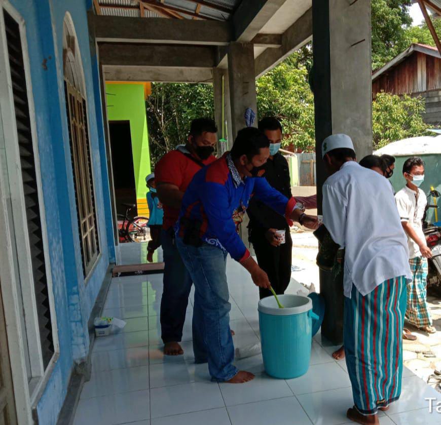 Anggota Satresnarkoba Polres Gumas sedang membagikan bubur kacang hijau kepada para jamaah usai melaksanakan salat Jumat di Masjid Al-Musttaqim. FOTO : tbn.