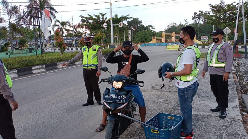 Operasi yustisi gabungan Polres Gumas dan Satpol PP saat meminta seorang pengendara motor untuk menggunakan masker dengan baik. FOTO : tbn.