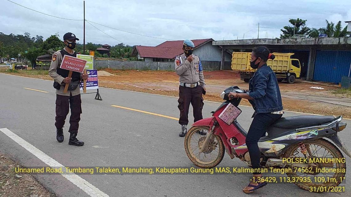 Anggota Polsek Manuhing sedang melaksanakan imbaun Prokes pencegahan Covid-!9. FOTO : tbn.