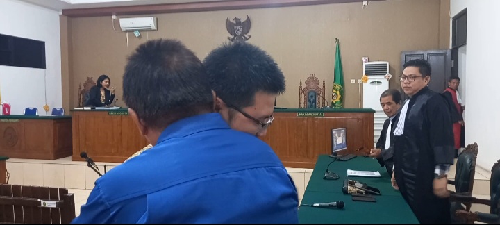 Jefri Suryatin dipeluk ayah kandungnya seusai sidang pembacaan putusan di Pengadilan Tipikor Palangka Raya, Kamis (31/8/2023). Foto: fer