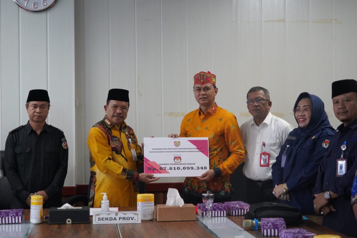 Sekda Prov. Kalteng H. Nuryakin saat menyerahkan NPHD kepada Ketua KPU Prov. Kalteng Sastriadi