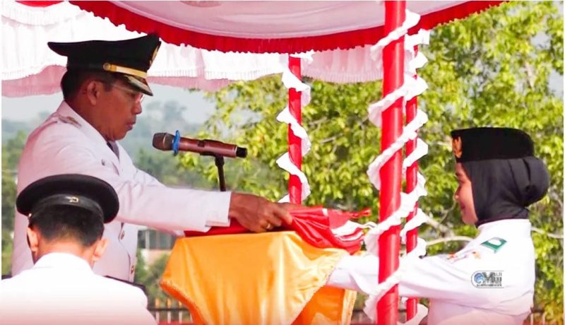 Bupati Murung Raya Perdie M Yoseph saat menyerahkan bendera merah putih