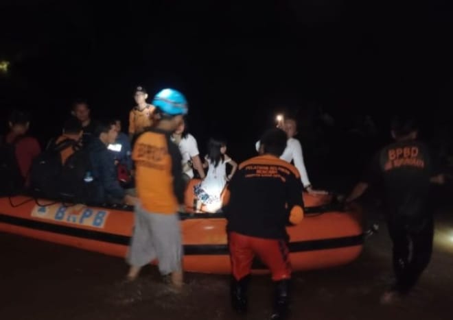 Tim Reaksi Cepat (TRC) dari Badan Penanggulangan Bencana Daerah (BPBD) Murung Raya (Mura) melakukan evakuasi para pengguna jalan yang tak dapat melintas, Jumat (1/12/2023) malam. Foto : Ist