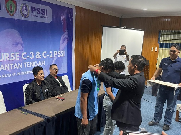 Sekretaris Asprov PSSI Kalteng Sigit Widodo, menyematkan kartu tanda peserta, tanda dimulainya kegiatan kursus wasit C2 dan C3, yang dilaksanakan selama tujuh hari di Palangka Raya, Rabu (20/12/2023), malam. Foto IST