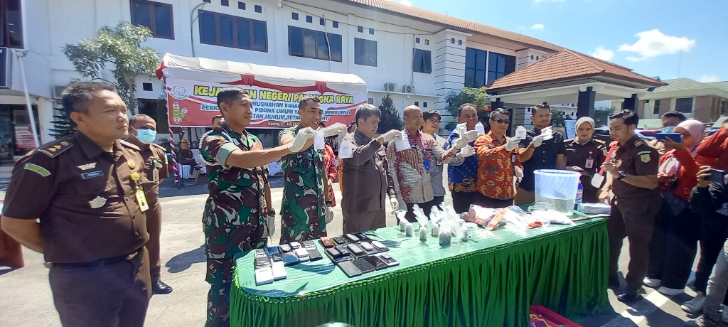 Kajari Palangka Raya Andi Murji Machfud (empat dari kiri) dan Forkopimda yang hadir menunjukkan barang-barang bukti yang akan dimusnahkan di halaman Kejari setempat, Kamis (27/7/2023). Foto: fer