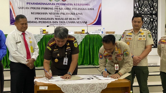 Kajari Palangka Raya, Andi Murji Machfud dan Kepala Satpol PP Kota  Palangka Raya, Berlianto menandatangani perjanjian kerja sama penanganan masalah hukum bidang perdata dan tata usaha negara di aula kejari setempat, Rabu (22/5/2024). Foto: ist