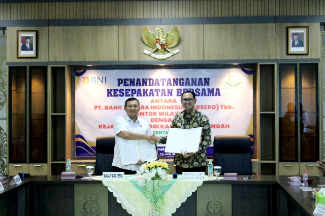 Kajati Kalteng Dr. Undang Mugopal, SH, M.Hum (kemeja putih) dan Regional Chief Executive Officer BNI Wilayah 09 Banjarmasin, Andy Yusdiman menunjukkan dokumen kerja sama Penanganan Masalah Hukum Bidang Perdata dan Tata Usaha Negara di Aula Lantai III Kantor Kejati setempat, Selasa (16/2024). Foto: Penkum Kejati Kalteng