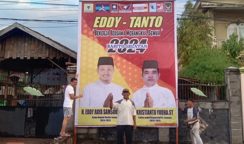 Nampak salah satu warga Barsel yang bangga dengan berdiri gagah baliho H.Eddy Raya Samsuri dan Kristianto Yudha yang akan mengikuti Pilkada 2024 Kabupaten Barsel. Foto : Ist