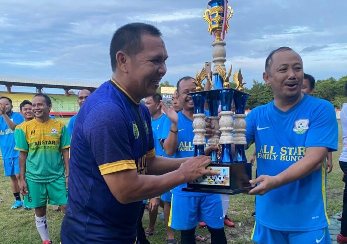 Ketua KONI Kalteng, H Edy Raya Syamsuri menyerahkan Piala  kepada pemenang sepakbola persahabatan segitiga kepada Kapten Tim All Star Palangka Raya, Gazali Rahman, Sabtu (20/3/2021). Foto : Ist