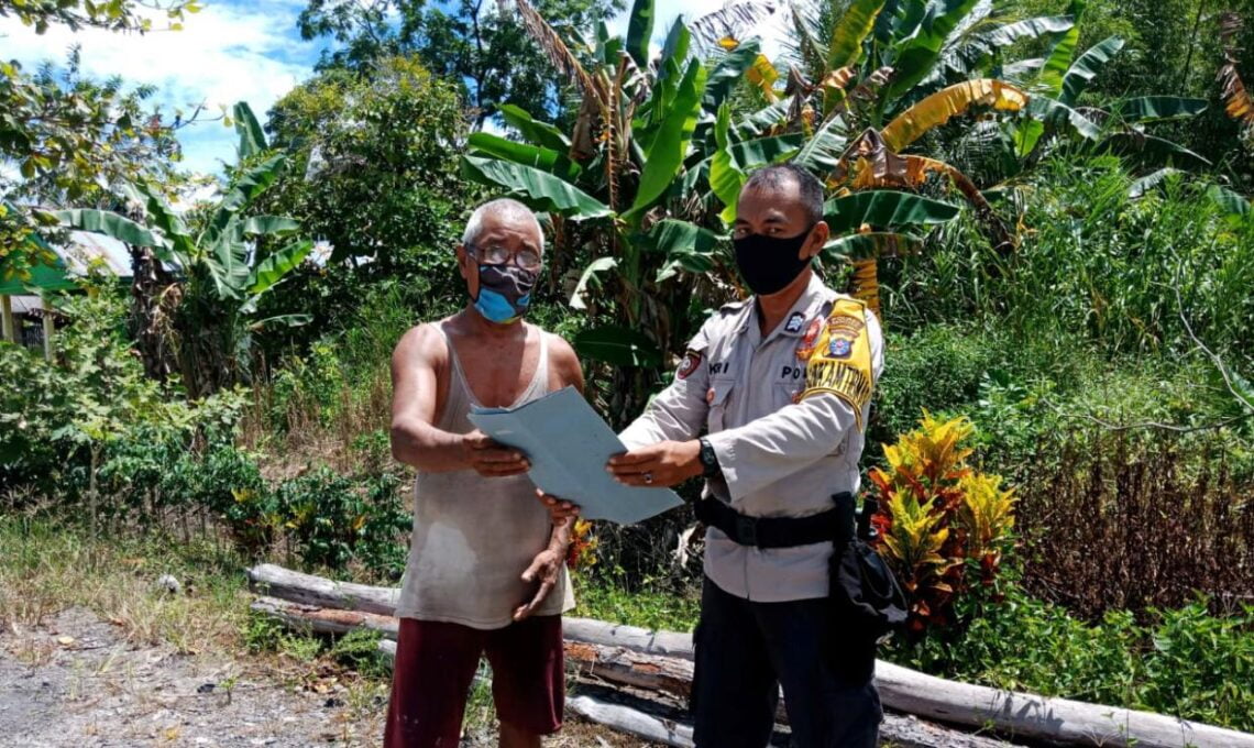 Personel Polsek Seruyan Hilir Bripka Guntur Syaputra saat mengajak masyarakat mencegah Karhutla melalui media spanduk berisikan larangan membakar hutan dan lahan di Desa Halimaung Kec. Seruyan Hilir Timur, Kab seruyan, Prov Kalteng, Minggu (21/03/2021) pagi. Foto : Tbn