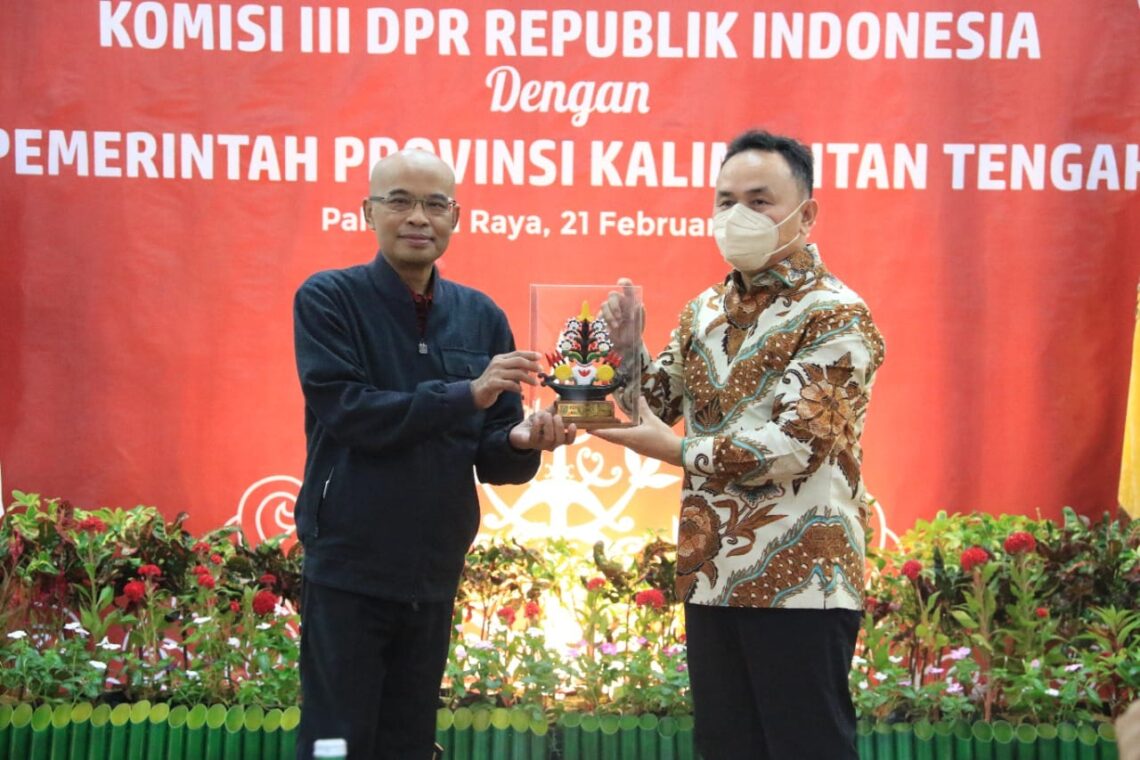 Gubernur Kalteng H. Sugianto Sabran saat menyerakan cinderamata dari Pemprov Kalteng kepada Ketua Komisi III DPR RI Desmond Junaidi Mahesa