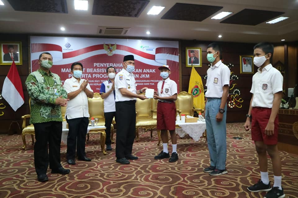 Sekda Fahrizal Fitri, mewakili Gubernur Kalteng, menyerahkan secara simbolis Manfaat Beasiswa Pendidikan kepada 3 (tiga) orang anak ahli waris dari 2 (dua) Peserta Program Jaminan Kecelakaan Kerja (JKK) dan Jaminan Kematian (JKM), bertempat di Aula Eka Hapakat, Kompleks Kantor Gubernur, Palangka Raya, Rabu (21/4/2021). Foto : BA