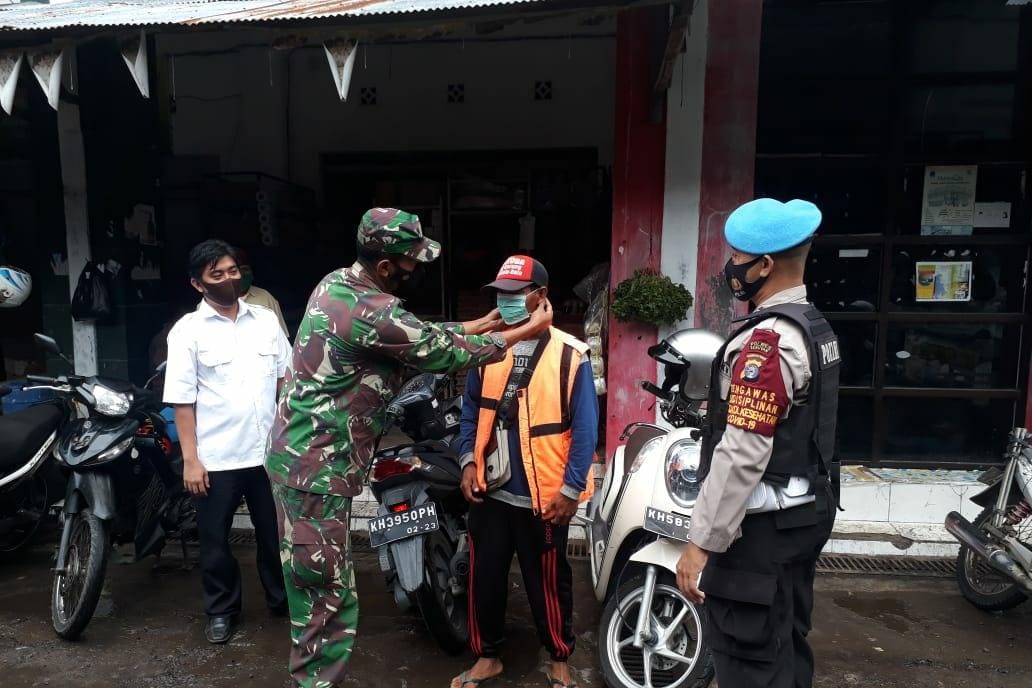 personel Polsek Seruyan, bersama Anggota Koramil Kuala Pembuang menggelar patroli pendisiplinan dengan menyambangi masyarakat yang beraktiftas di Pasar Saik agar senantiasa mematuhi Protokol Kesehatan (Prokes), Selasa (23/03/2021) pagi. Foto : Tbn