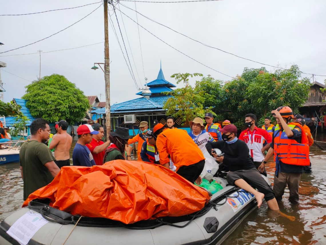 Relawan dari Kabupaten Barito Selatan (Barsel) membagikan logistik di lokasi banjir di Desa Keramat Amuntai, Kalsel, Senin (25/1/2021). Foto : ari