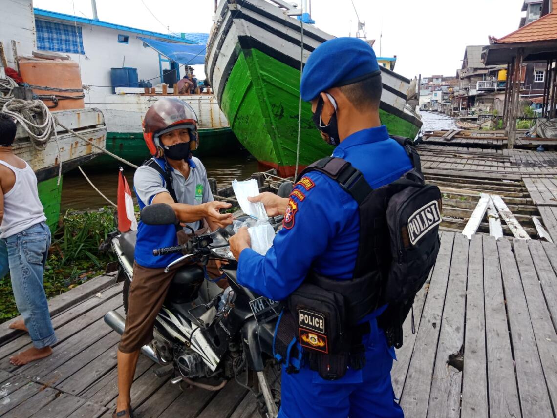 Satpolairud Polres Seruyan imbau masyarakat Patuh Protkes Covid -19  dengan membagikan masker di lokasi padat aktifitas masyarakat Dermaga Bongkar Muat Kuala Pembuang jalan Ais Nasution Kel Kuala Pembuang I Kab Seruyan, Selasa (27/07/2021). Foto : Tbn
