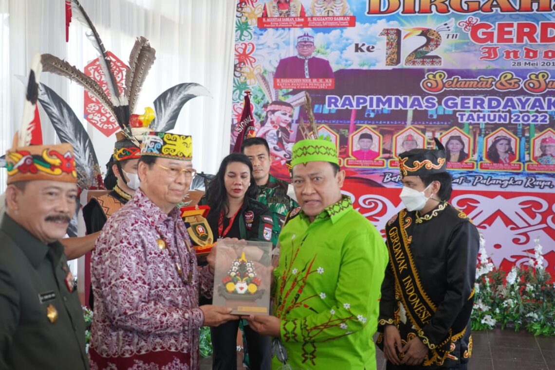 Pemberian Plakat Kepada Presiden Majelis Adat Dayak Nasional Marthin Billa