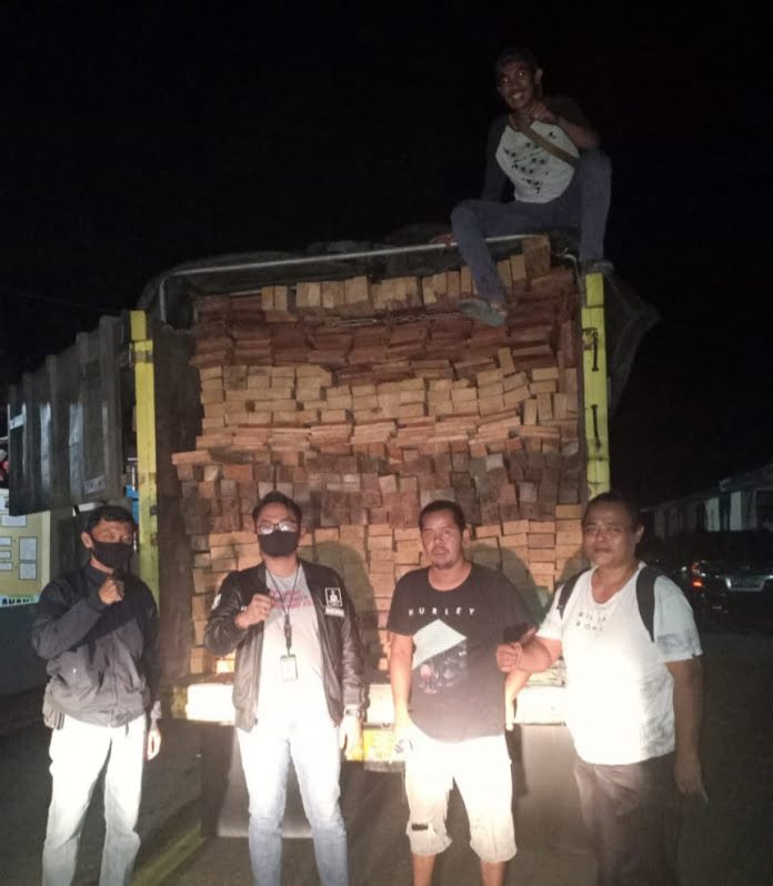 Personil Satreskrim Polres Bartim di depan truk bermuatan kayu yang diduga tidak berdokumen, Selasa (28/7/2020). Foto : TBN