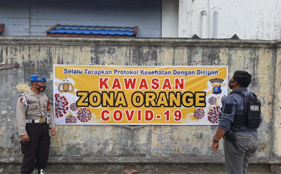 Anggota Polsek Seruyan Hilir, Polres Seruyan memasang spanduk peringatan Zona Orange di pasar Saik Kuala Pembuang, Selasa (30/03/2021). Foto : Tbn
