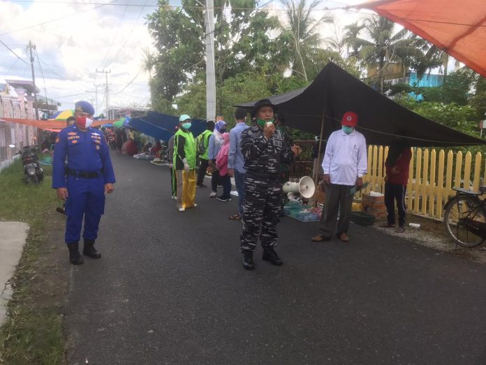 Petugas memberikan pengumuman terkait penutupan Pasar Sabtu di Selat Hilir Kapuas. Foto : Tbn