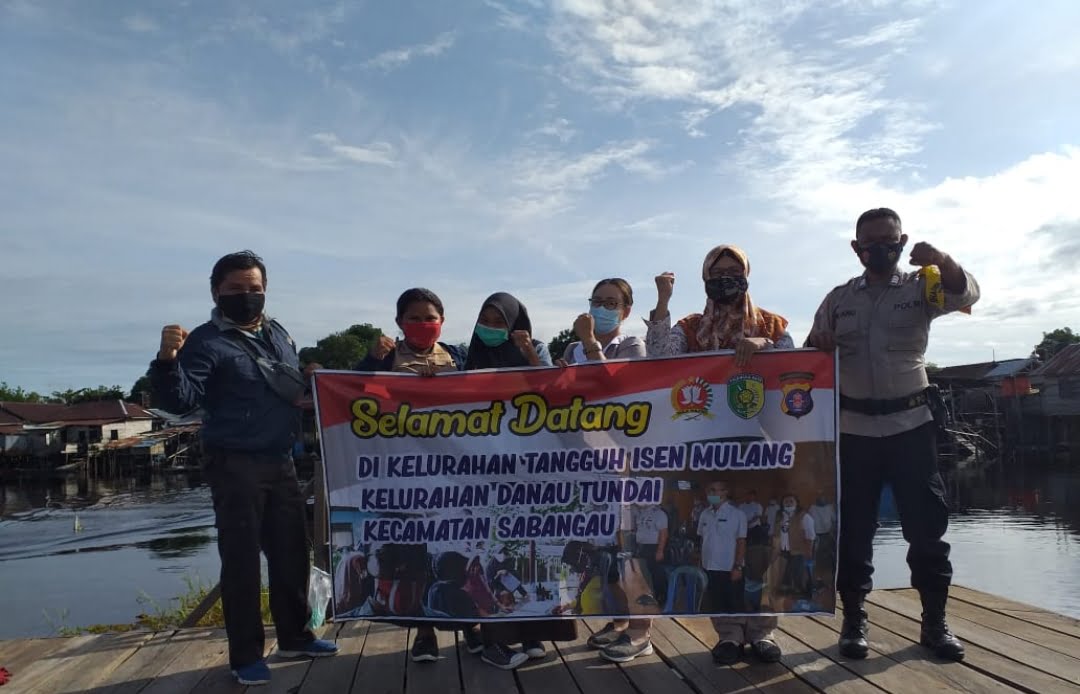 Bhabinkamtibmas Polsek Sabangau, Bripka Sutrisno Piliang bersama warga Kelurahan Danau Tundai usai gotong royong dalam rangka mencanangkan program kampung tangguh. FOTO : tbn.