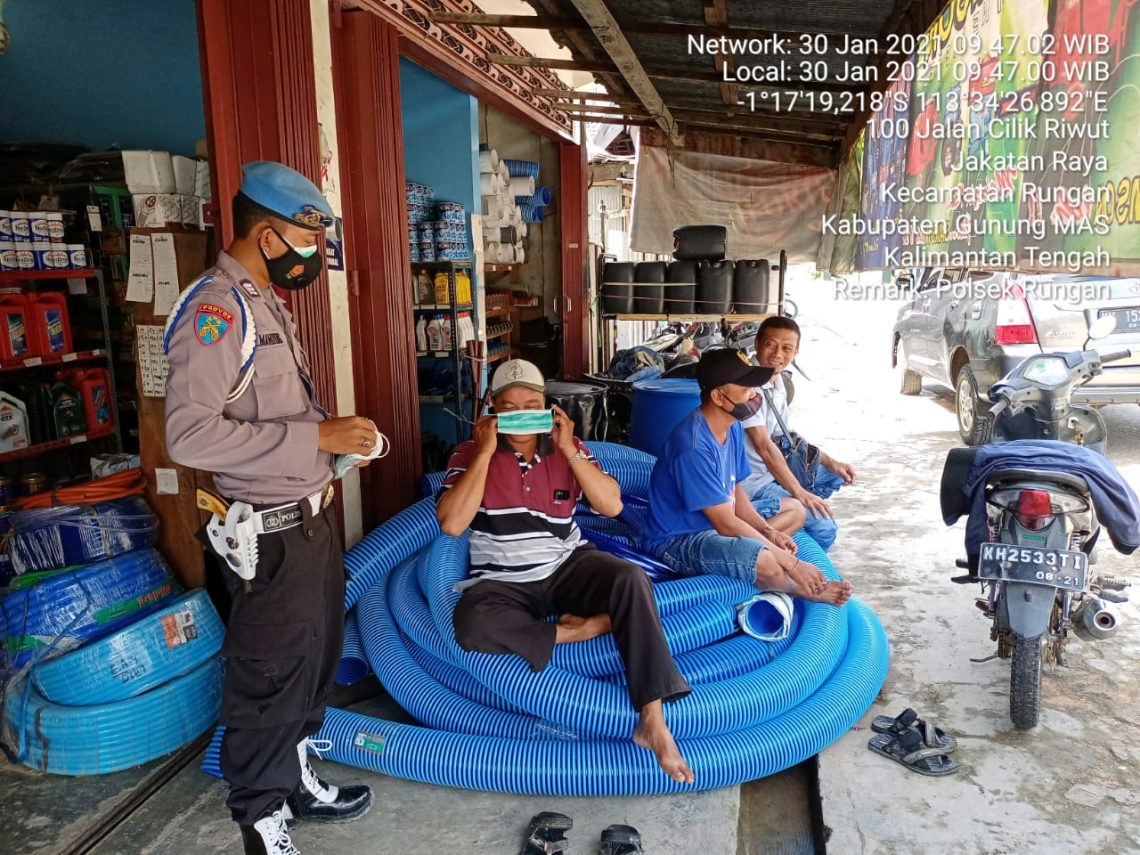 Anggota Polsek Rungan saat memberikan masker kepada warga yang tidak memakai. FOTO : tbn.