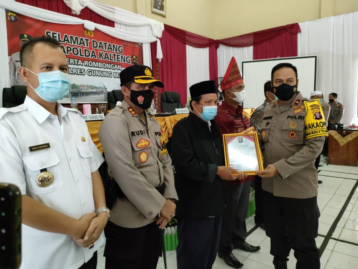 Wakapolda Kalteng Brigjen Pol Drs. Suryanbodo Asmoro, M.M., memberikan piagam penghargaan kepada tokoh agama dan tokoh masyarakat disaksikan Bupati Gumas Jaya S. Monong. FOTO : tbn.