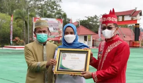 Bupati Murung Raya Perdie M Yoseph didampingi Kepala Dinas Kesehatan dr Suria Siri menerima penghargaan pencapaian UHC yang kelima yang diserahkan Pps Kepala BPJS Kesehatan Cabang Muara Tewehn Istiari Hardini.