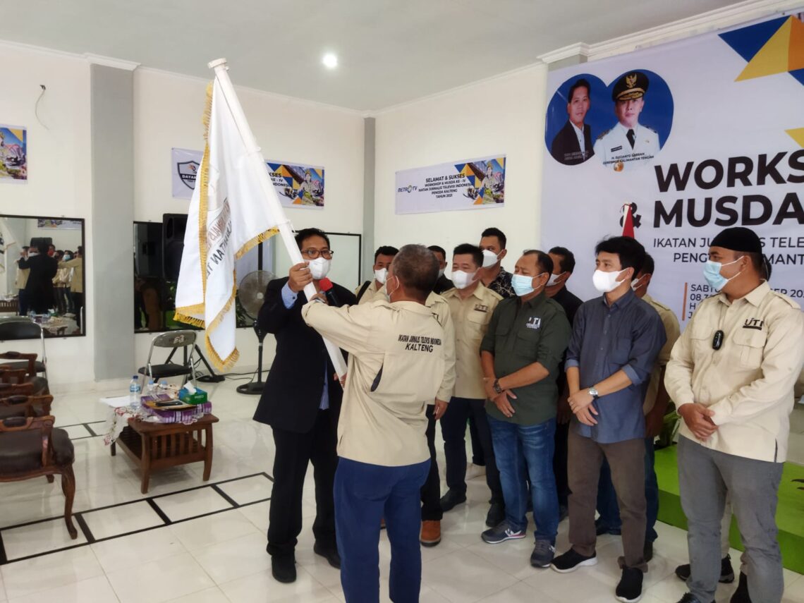 H Tantawi Djauhari menerima pataka dari Ketua Umum IJTI Pusat, Yadi Hendrayana, usai pelantikan di Palangka Raya, Sabtu (16/10/2021). Foto : hairil s.