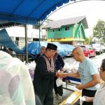 Kajari Palangka Raya Andi Murji Machfud (berkopiah) memberikan sekantong daging hewan kurban kepada salah seorang warga di halaman kejari setempat, Minggu (2/7/2023) siang. (Ist)
