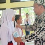 Kepala SMPN 1 Katingan Kuala, M.Yusri membuka kegiatan MPLS Menyenangkan ditandai dengan pemasangan papan nama peserta didik baru. (Foto: ist)