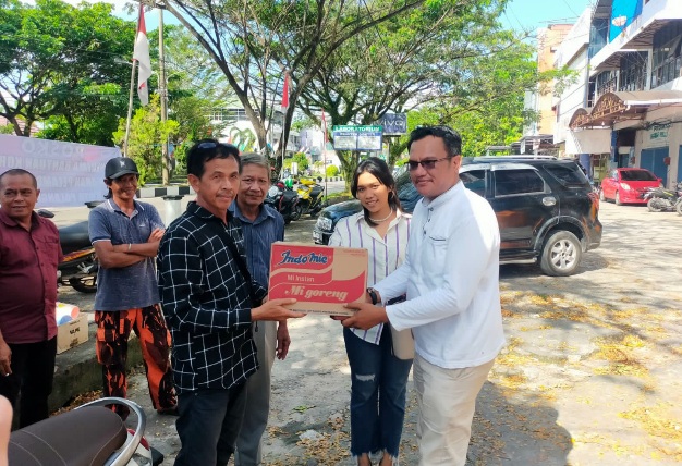 Jhondri FS (kanan) menyerahkan bantuan berupa sembako, obat-obatan dan vitamin didampingi Lovina Tampubolon (dua dari kanan) kepada Safruddin selaku Ketua RT 005 RW 008 Flamboyan Bawah mewakili warga RT 004 RW 008 yang terkena musibah kebakaran (kiri) di Palangka Raya, Kamis (3/8/2023). Foto: ist.