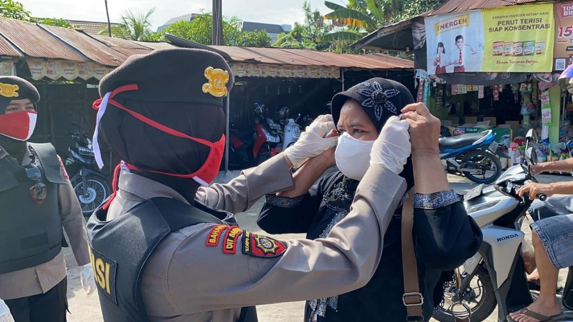 Polwan Ditsamapta Polda Kalteng membagikan masker kepada warga di Pasar Besar Palangka Raya, Sabtu (20/6/2020). Foto : Tbn