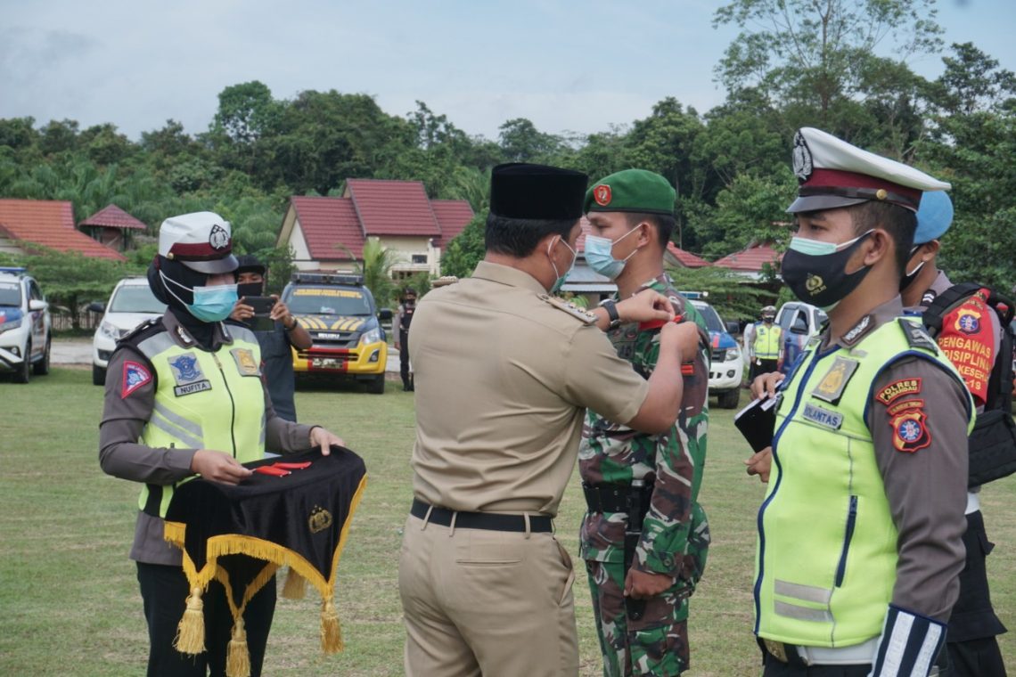 Bupati Lamandau, H. Hendra Lesmana saat menyematkan tanda khusus kepada petugas gabungan pengamanan Nataru. FOTO : by.