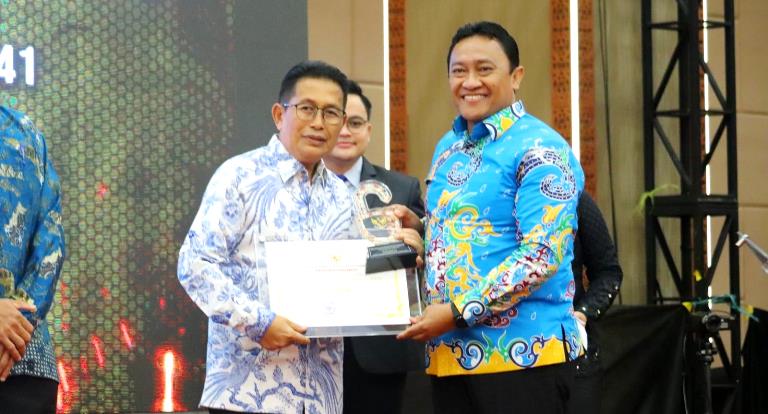 Wakil Bupati Murung Raya Rejikinoor menerima piagam penghargaan Kualifikasi PPID Utama katagori informatif yang diserahkan Wakil Gubernur Kalimantan Tengah H Edy Pratowo di M Bahalap Hotel Palangka Raya, Kamis (24/11/2022). Foto : Ist